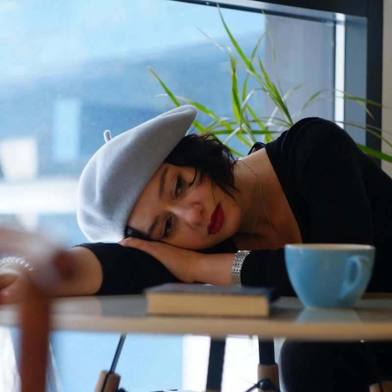 Mujer reflexionando sobre las expectativas sociales y el cansancio emocional que generan